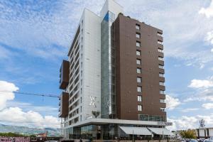 ein hohes weißes und braunes Gebäude mit einem Himmel in der Unterkunft Apartments LORA in Apart-hotel in Budva