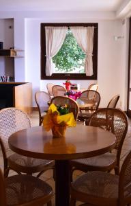 una sala da pranzo con tavoli, sedie e una finestra di Grem Bike Hostel a Premolo