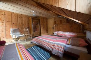 ein Schlafzimmer mit 2 Betten und einem Stuhl in einer Hütte in der Unterkunft Riversong Centre Thermal in Les Plans-sur-Bex