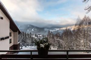 a balcony with a view of a snow covered mountain at Hotel Horní Pramen in Špindlerův Mlýn