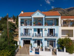 una casa azul con techo rojo en Myrto Apartments, en Agia Efimia