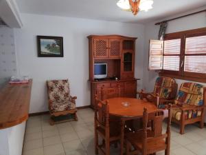 a dining room with a table and a tv at Apartamentos Cerro Negro in Capileira