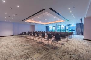 a room with a row of chairs in a room with windows at Barcel&oacute; Budapest in Budapest