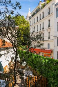 a building with a tree in front of it at Le Village Montmartre by Hiphophostels in Paris