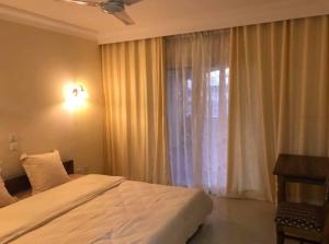 a bedroom with a large bed and a window at HOTEL MENABE in Morondava