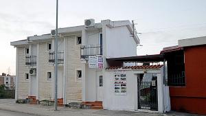 een wit gebouw aan de straatkant bij Apartments Kruna Jovanović in Sutomore
