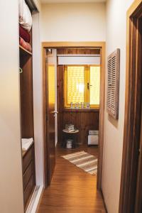 a hallway leading to a bathroom with a sink at Casinha dos Relógios in Penhas da Saúde