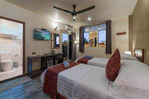 ein Schlafzimmer mit 2 Betten und ein Badezimmer mit einem Waschbecken in der Unterkunft Paguro Beach Inn in Ukulhas