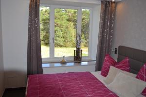 奧茨巴德賓茲的住宿－Arkona-Meeresblick am Prorer Wiek，一间卧室配有一张带紫色棉被的床和窗户。