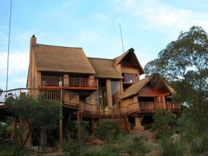 a large wooden house with a large deck at Ngong Hill, Mabalingwe in Warmbaths