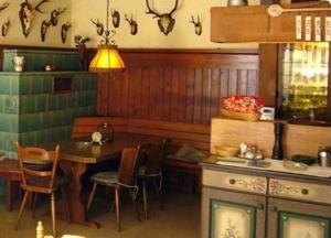 eine Küche mit einem Tisch, Stühlen und einem Herd in der Unterkunft Gasthaus-Pension Waldesruhe in Schwarzbach