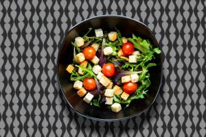a bowl filled with a salad with tomatoes and cheese at Stay Hotel Faro Centro in Faro