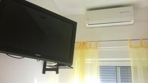 a flat screen tv sitting on a wall next to a window at Apartman Renata in Omiš