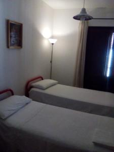- 2 lits dans une chambre avec une lampe et une fenêtre dans l'établissement Casa Levante, à Castelbuono