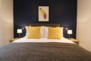 a bedroom with a large bed with yellow pillows at Heart of Leeds City Centre Living - Sleeps 6 in Leeds