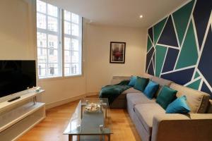 a living room with a couch and a tv at Heart of Leeds City Centre Living - Sleeps 6 in Leeds
