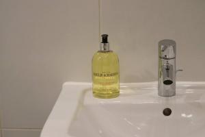 a bottle of alcohol sitting on a bathroom sink at Heart of Leeds City Centre Living - Sleeps 6 in Leeds