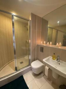 a bathroom with a shower and a toilet and a sink at Heart of Leeds City Centre Living - Sleeps 6 in Leeds