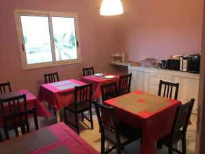 a restaurant with red tables and chairs and a kitchen at Borgo Palombaio in Catania