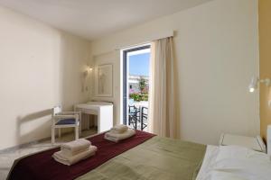 a bedroom with a bed with two towels on it at Ariadne Hotel in Platanes