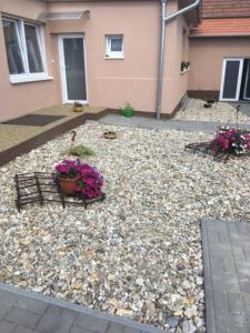 a yard with rocks and flowers in front of a house at Ubytování U babičky in Lanžhot