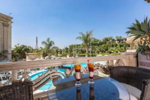 two drinks on a table on a balcony with a pool at Al Masa Hotel Nasr City in Cairo