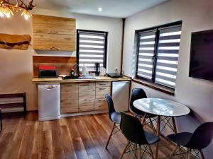 a kitchen with a table and chairs in a room at Chata Umilajka Bieszczady in Czarna +16 photos