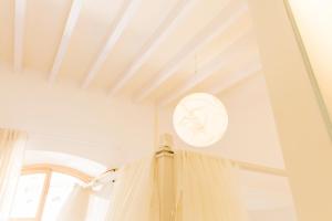 a white room with a window and a curtain at Fonda Llabres Boutique in Alcudia