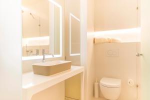 a white bathroom with a sink and a toilet at Fonda Llabres Boutique in Alcudia