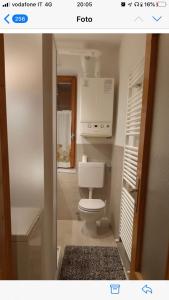 カステッロ・テジーノにあるAppartamento Castello Tesinoのバスルーム(白いトイレ付)が備わります。