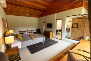 ein Schlafzimmer mit einem Bett und einem Tisch in einem Zimmer in der Unterkunft Sítio dos Lagos in Domingos Martins