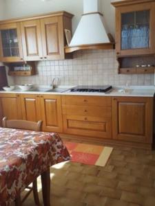 a kitchen with wooden cabinets and a table and a stove at CASA ALESSANDRA in Chiuro