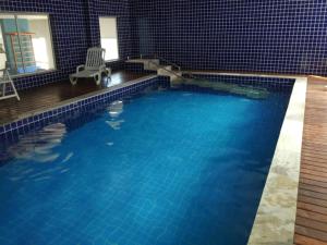 a swimming pool with blue water in a house at AP Clube Lazer Total in Bertioga
