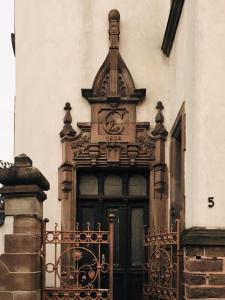 ein Gebäude mit einer Tür mit einer Uhr drauf in der Unterkunft LE BRETZEL in Colmar