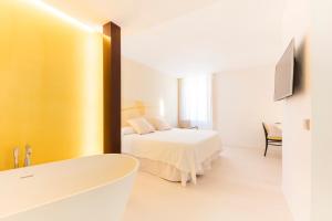 a bathroom with a bed and a bath tub in a room at Fonda Llabres Boutique in Alcudia