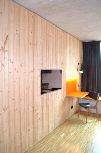 a room with a wooden wall with a tv on it at Hotel & Restaurant Zur Glocke in Höchstädt an der Donau