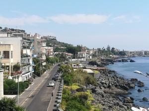 een uitzicht op een stad met een rivier en gebouwen bij La terrazza dei Normanni in Aci Castello
