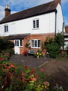 a white house with a bench in front of it at rosedale cottage in Walsgrave on Sowe