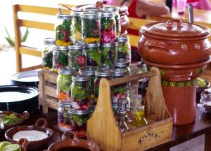 a table with many glass jars filled with flowers at Tendo Glamping in Tepoztlán