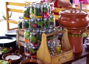 een tafel met veel glazen potten gevuld met bloemen bij Tendo Glamping in Tepoztlán