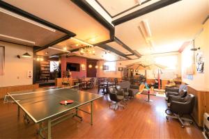 a large room with a ping pong table and chairs at Kagura White Horse Inn in Yuzawa