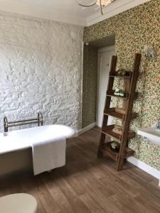 a bathroom with a white bath tub next to a wall at Branxholme Castle (Bed & Breakfast) in Hawick