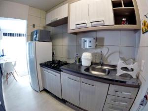 a small kitchen with a sink and a refrigerator at Studio Central XV Master Collection in Passo Fundo