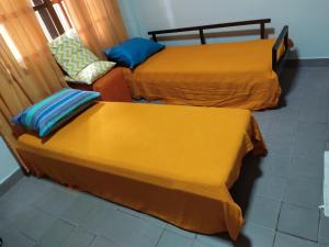 duas camas com capas amarelas num quarto em Departamento centrico en Posadas, garage opcional D4 em Posadas