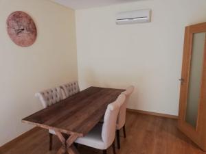 a dining room with a wooden table and chairs at Beach Sea View Apartment in Setúbal