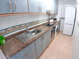 une cuisine avec un évier et un réfrigérateur dans l'établissement Apartamento Grande-Centro Barrio Playa, à Alicante