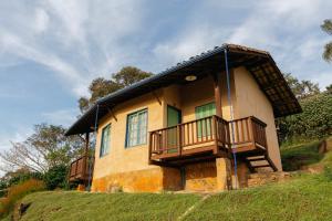 a house with a balcony on a hill at Cafezal em Flor Turismo e Cafés Especiais in Monte Alegre do Sul