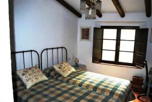 a bedroom with a bed and a window at El Alojamiento Rural de Peter in Aracena +51 photos