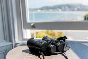 a pile of binoculars sitting on a table with a window at Belmont Llandudno in Llandudno