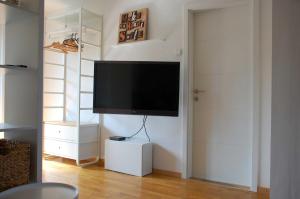 リュブリャナにあるApartments Peter & Free parkingの壁に薄型テレビが取り付けられたリビングルーム